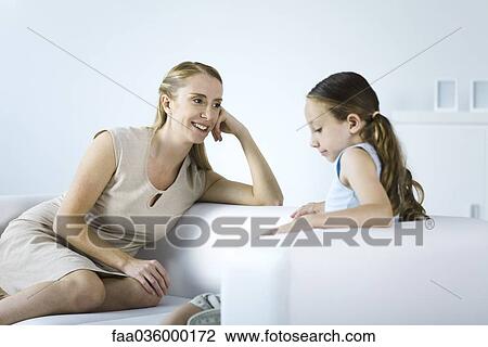 Mother and daughter seated face to face on sofa, talking View Large Photo Image Stock Image - Mother and daughter seated face to face on sofa, talking. Fotosearch