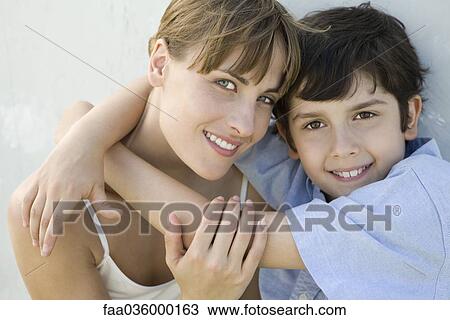 Mother and son embracing, both smiling at camera View Large Photo Image Stock Image - Mother and son embracing, both smiling at camera. Fotosearch
