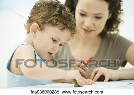 Mother and son sitting together, coloring with crayons View Large Photo Image Stock Photography - Mother and son sitting together, coloring with crayons. Fotosearch