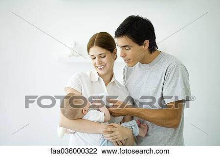 Mother holding baby, husband feeding baby with a bottle View Large Photo Image Stock Image - Mother holding baby, husband feeding baby with a bottle. Fotosearch