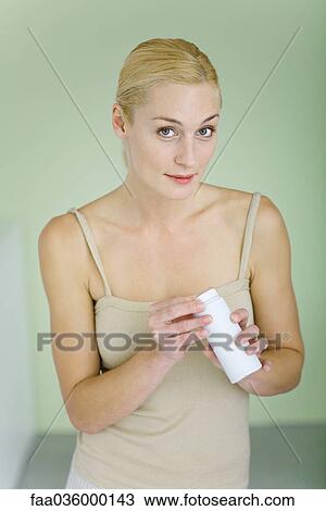 Mother holding bottle of baby powder, smiling at camera View Large Photo Image Stock Image - Mother holding bottle of baby powder, smiling at camera. Fotosearch