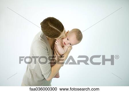 Mother kissing infant on the cheek, baby looking down View Large Photo Image Stock Image - Mother kissing infant on the cheek, baby looking down. Fotosearch