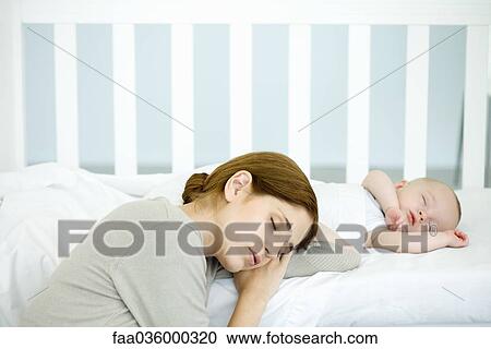 Mother resting head beside sleeping infant in crib, eyes closed View Large Photo Image Stock Image - Mother resting head beside sleeping infant in crib, eyes closed. Fotosearch