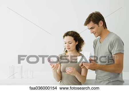 New parents looking at baby bottle, man holding milk cartons View Large Photo Image Picture - New parents looking at baby bottle, man holding milk cartons. Fotosearch