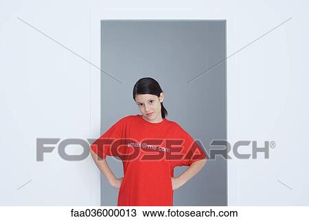 Preteen girl wearing tee-shirt printed with e-mail address, hands on hips, looking at camera View Large Photo Image Stock Image - Preteen girl wearing tee-shirt printed with e-mail address, hands on hips, looking at camera. Fotosearch