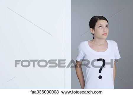 Preteen girl wearing tee-shirt printed with question mark, looking up View Large Photo Image Stock Photo - Preteen girl wearing tee-shirt printed with question mark, looking up. Fotosearch