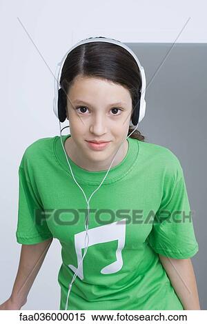 Preteen girl wearing tee-shirt printed with musical notes, listening to headphones, smiling View Large Photo Image Stock Photography - Preteen girl wearing tee-shirt printed with musical notes, listening to headphones, smiling. Fotosearch