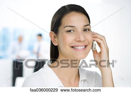 Professional woman using cell phone, smiling at camera View Large Photo Image Stock Photo - Professional woman using cell phone, smiling at camera. Fotosearch