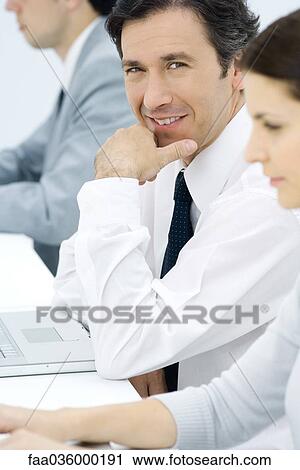 Professionals working, focus on man in center View Large Photo Image Stock Image - Professionals working, focus on man in center. Fotosearch