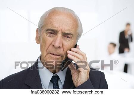 Senior businessman using cell phone, furrowing brow View Large Photo Image Stock Image - Senior businessman using cell phone, furrowing brow. Fotosearch