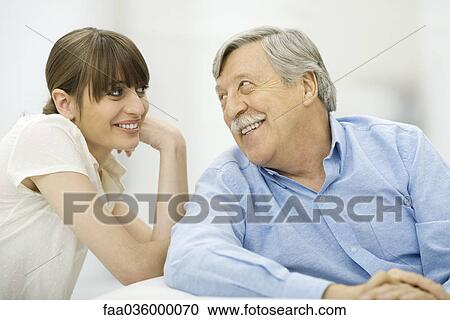 Senior man and adult daughter smiling at each other, portrait View Large Photo Image Stock Image - Senior man and adult daughter smiling at each other, portrait. Fotosearch