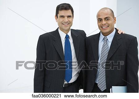 Two businessman, one with arm around the other's shoulder, smiling at camera View Large Photo Image Stock Image - Two businessman, one with arm around the other's shoulder, smiling at camera. Fotosearch