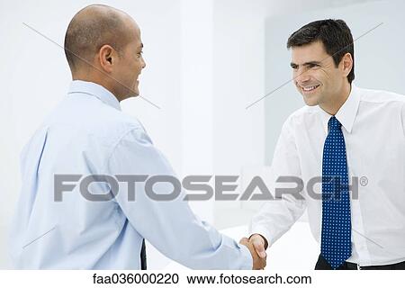 Two businessmen shaking hands, smiling View Large Photo Image Stock Image - Two businessmen shaking hands, smiling. Fotosearch