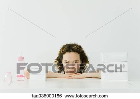 Woman beside stacked milk cartons and baby bottle, head resting on arms, smiling at camera View Large Photo Image Stock Photograph - Woman beside stacked milk cartons and baby bottle, head resting on arms, smiling at camera. Fotosearch