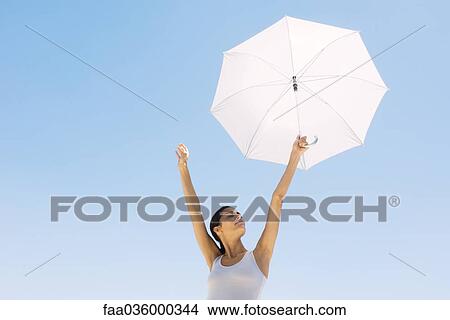 Woman holding up parasol, eyes closed View Large Photo Image Picture - Woman holding up parasol, eyes closed. Fotosearch
