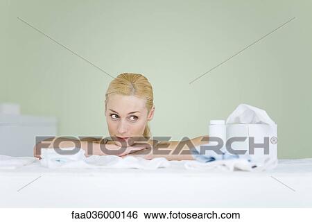 Stock Photograph - Woman in nursery, resting head on arms, looking away, smiling. Fotosearch