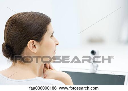 Woman sitting in front of webcam, looking away, rear view View Large Photo Image Stock Photograph - Woman sitting in front of webcam, looking away, rear view. Fotosearch