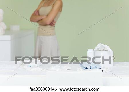 Woman standing in nursery, arms folded, cropped View Large Photo Image Stock Photography - Woman standing in nursery, arms folded, cropped. Fotosearch
