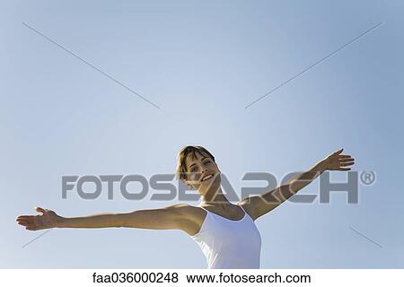 Woman standing outdoors with arms out, smiling at camera View Large Photo Image Stock Photo - Woman standing outdoors with arms out, smiling at camera. Fotosearch