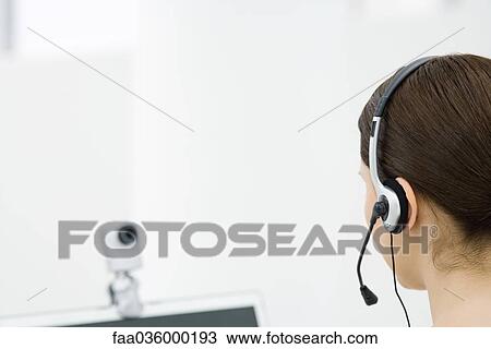 Woman wearing headset, looking at webcam, rear view View Large Photo Image Stock Image - Woman wearing headset, looking at webcam, rear view. Fotosearch