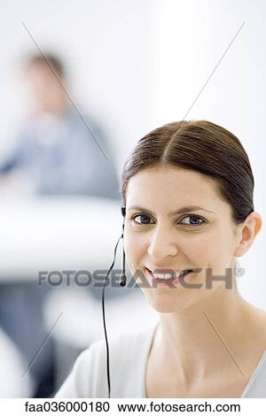 Woman wearing headset, smiling at camera, portrait View Large Photo Image Stock Image - Woman wearing headset, smiling at camera, portrait. Fotosearch