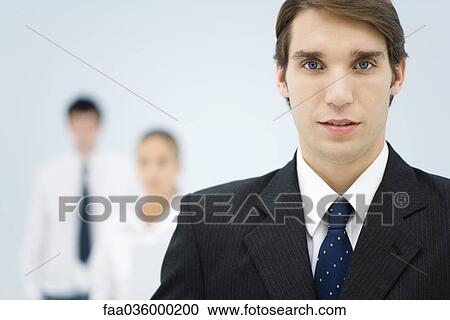Young businessman in office, looking at camera View Large Photo Image Stock Image - Young businessman in office, looking at camera. Fotosearch
