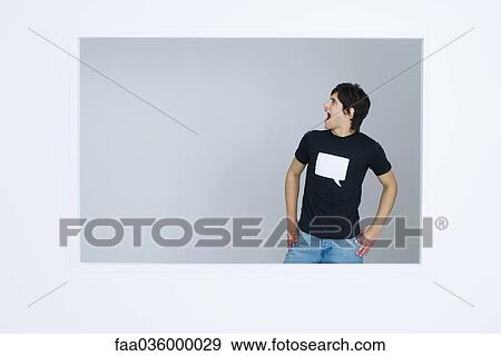 Young man wearing tee-shirt printed with blank word bubble, shouting, hands on hips View Large Photo Image Stock Photo - Young man wearing tee-shirt printed with blank word bubble, shouting, hands on hips. Fotosearch