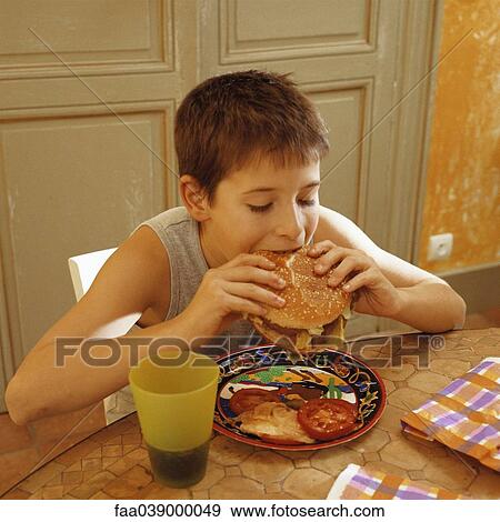 Boy eating hamburger View Large Photo Image Stock Photo - Boy eating hamburger. Fotosearch