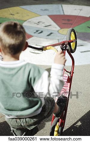 Boy playing with scooter on playground, rear view View Large Photo Image Stock Image - Boy playing with scooter on playground, rear view. Fotosearch
