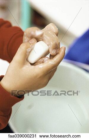 Stock Image - Child washing hands, cropped view. Fotosearch