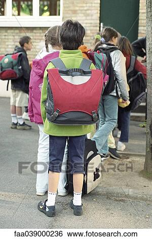 Stock Photograph - Children filing into elementary school entrance. Fotosearch