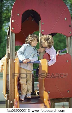 Stock Image - Children playing on slide. Fotosearch