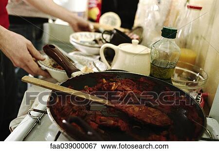 Stock Photo - Cleaning up kitchen after mealtime. Fotosearch