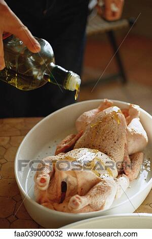 Drizzling olive oil on chickens View Large Photo Image Stock Image - Drizzling olive oil on chickens. Fotosearch