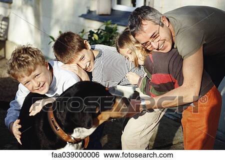 Stock Photograph - Family posing with dog. Fotosearch