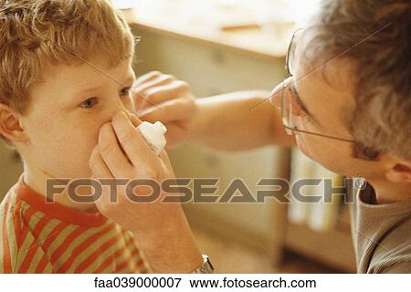 Stock Photo - Father putting ointment on boy's face. Fotosearch