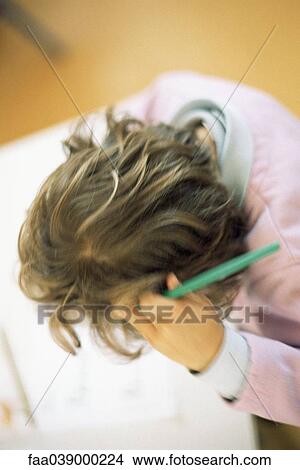 Picture - Girl holding pen, high angle view. Fotosearch