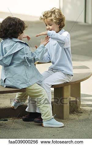 Girls playing clapping game on bench View Large Photo Image Stock Photograph - Girls playing clapping game on bench. Fotosearch