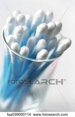 Picture - Glass containing supply of blue cotton swabs. Fotosearch