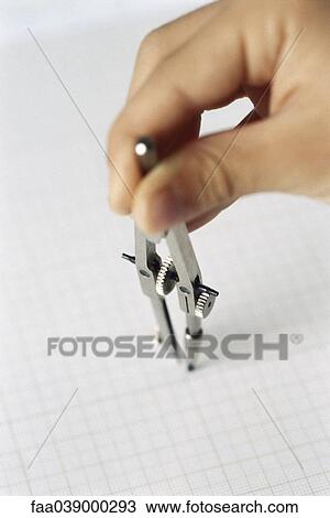 Stock Image - Hand holding drawing compass. Fotosearch