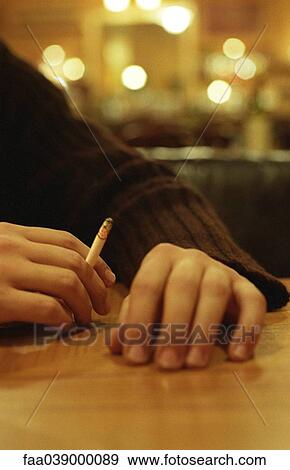 Stock Photo - Hand holding lit cigarette. Fotosearch