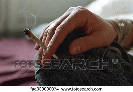 Hand holding smoking joint View Large Photo Image Picture - Hand holding smoking joint. Fotosearch