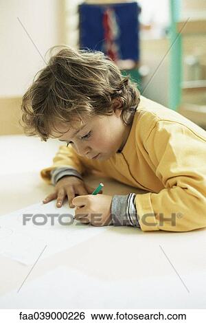 Stock Photograph - Little girl drawing at desk. Fotosearch