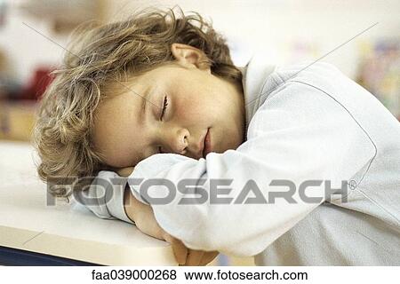 Little girl napping with head on desk View Large Photo Image Stock Photo - Little girl napping with head on desk. Fotosearch