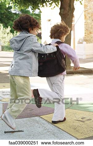 Stock Image - Little girls playing hopscotch together. Fotosearch