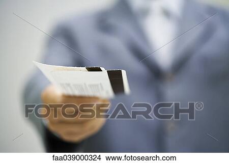 Man in suit holding out tickets View Large Photo Image Picture - Man in suit holding out tickets. Fotosearch