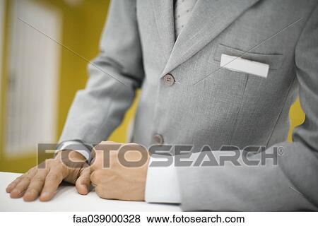 Man in suit standing behind counter, wearing blank name tag View Large Photo Image Stock Photo - Man in suit standing behind counter, wearing blank name tag. Fotosearch
