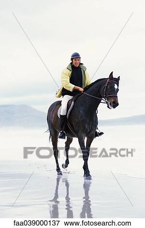 Man riding horse on beach View Large Photo Image Stock Photo - Man riding horse on beach. Fotosearch