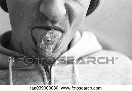 Man sticking out pierced tongue, candy bear stuck to piercing View Large Photo Image Stock Image - Man sticking out pierced tongue, candy bear stuck to piercing. Fotosearch