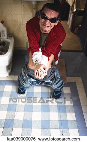 Stock Photograph - Man using toilet, grimacing. Fotosearch